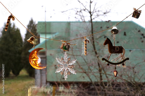 photo of a Christmas decorative garland with toys on the window in the village