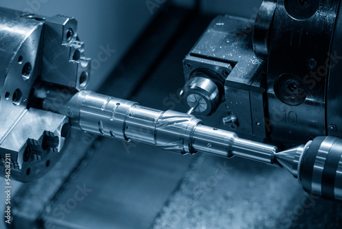 The multi-tasking CNC lathe machine groove cutting the brass shaft parts by milling spindle.