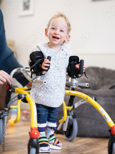 Boy with cerebral palsy using mobility walker and leg braces
