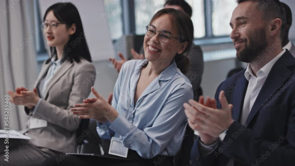 Slow motion of modern ethically diverse business people applauding to speaker and discussing presentation Slow motion of modern ethically diverse business people applauding to speaker and discussing presentation