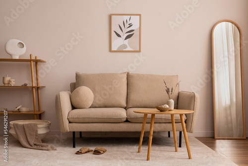 Creative composition of living room interior with mock up poster frame, elegant beige sofa, round wooden coffee table, modern mirror, classic consola, round pillow, beige plaid and stylish accessories © FollowTheFlow