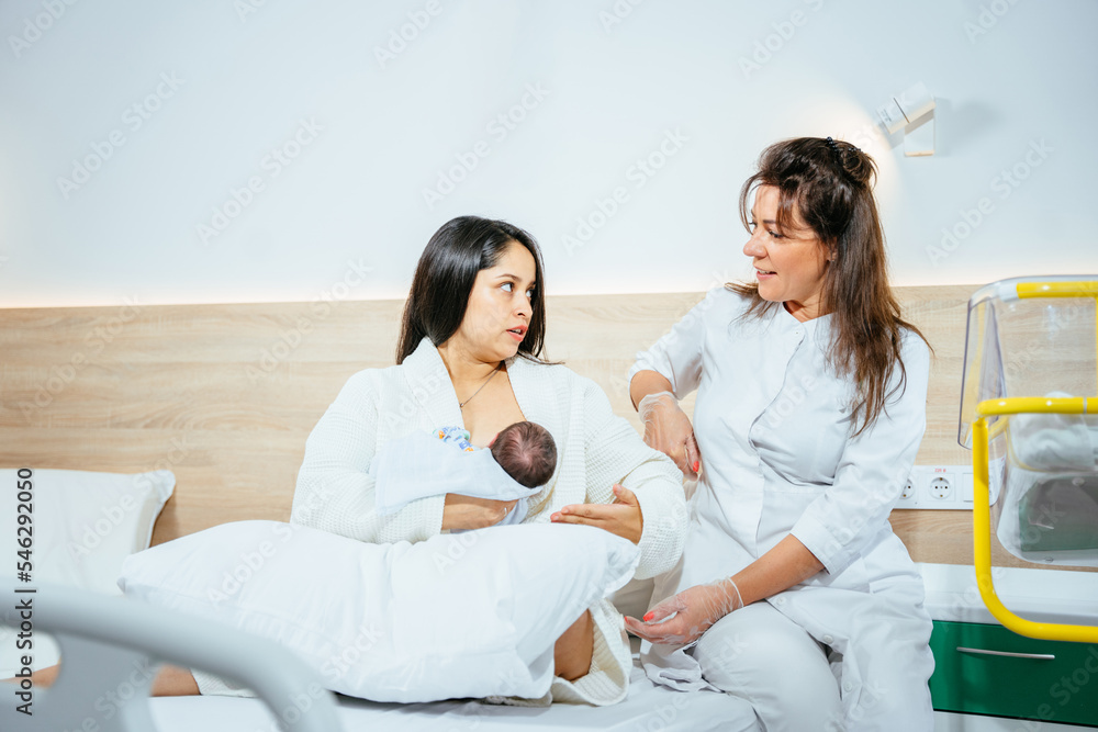 Obraz premium Concept of lactation infant feeding. Female doctor, breastfeeding specialist, nurse and new mom to breastfeed infant at hospital room.