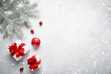Merry Christmas and Happy Holidays greeting card, frame, banner. New Year. Noel. Christmas red ornaments and gift on light background top view. Winter xmas holiday theme. Flat lay	
