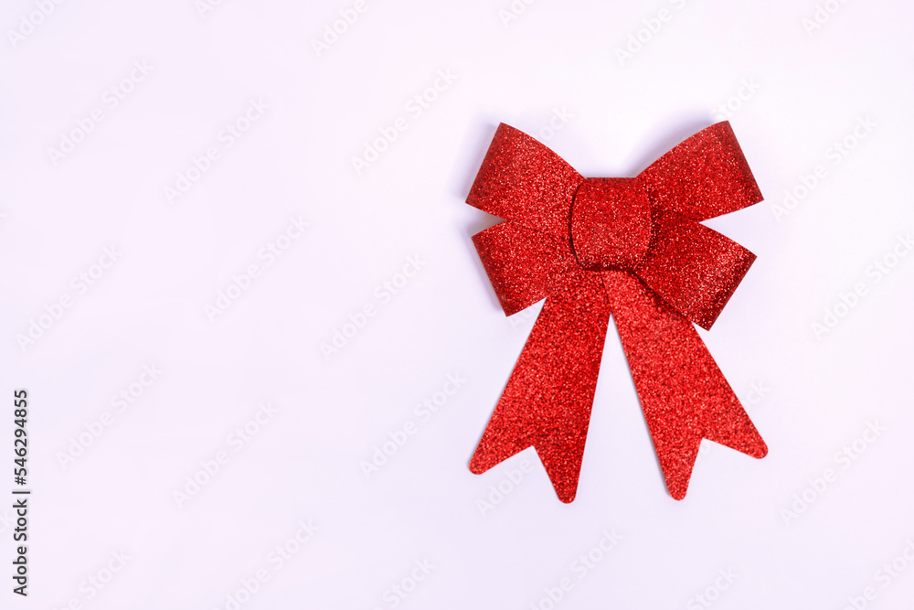 Red gift bow with sequins. Ribbon. Isolated on white background with copy space Red gift bow with sequins. Ribbon. Isolated on white background with copy space