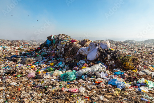 Konstfotografi Closeup of burning trash piles in landfill with flying crows over the site