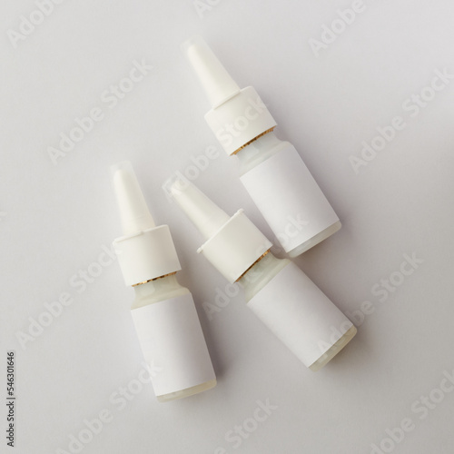 plastic nasal spray bottles mockup, medical moisturizer for flu and allergies, pharmaceutical aerosol with pump on a neutral gray background, with blank label