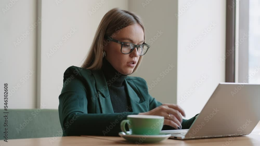 serious woman is working with laptop in cafe or coworking space, lawer or real estate agent serious woman is working with laptop in cafe or coworking space, lawer or real estate agent