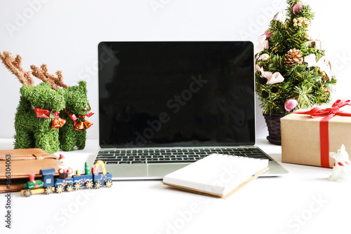 Laptop computer with Christmas decorations on white background