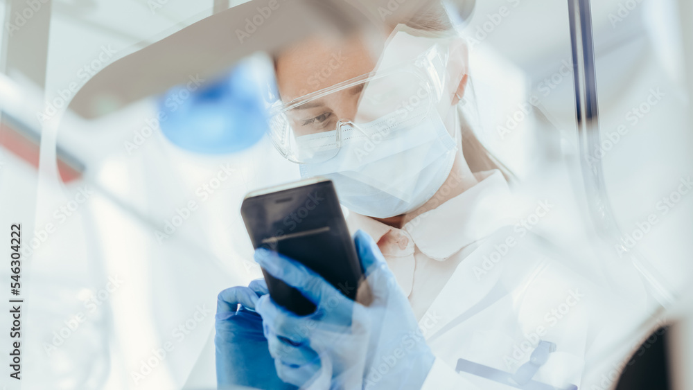bottom view. female scientist looking at the screen of her smartphone.