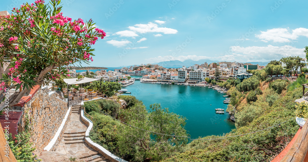 Agios Nikolaos, crete island, greece: view over lake Voulismeni (Vouliagmeni) and the pittoresk harbour city - obrazy, fototapety, plakaty 