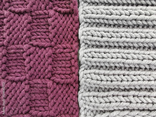 Purple and gray knitted pieces of knitted fabric. Knitted patterns and textures close up. Handmade and needlework hobbies. 