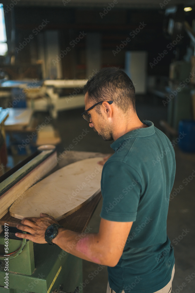 Craftsman polishing wood product at factory Craftsman polishing wood product at factory