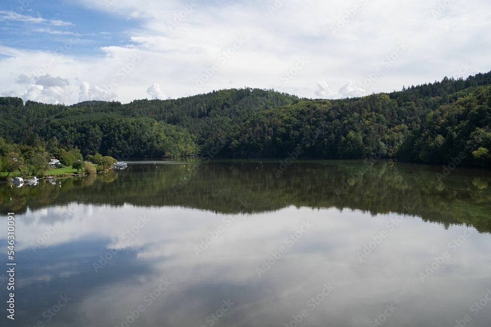 Beautiful view of a lakeside with the reflection of a forested landscape in Slovenia Beautiful view of a lakeside with the reflection of a forested landscape in Slovenia