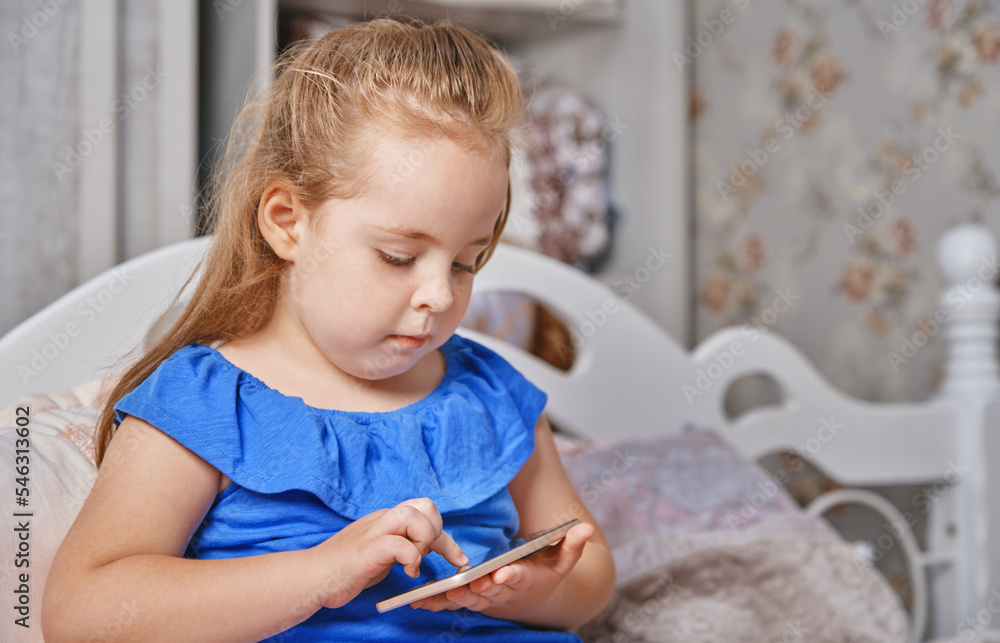 Little girl playing video games on mobile phone Little girl playing video games on mobile phone