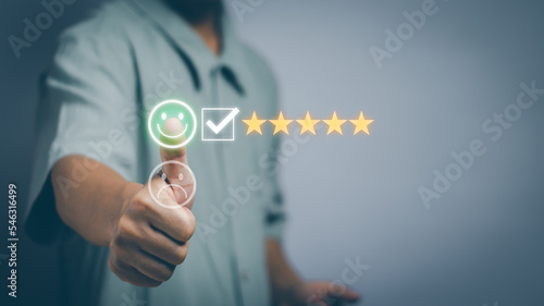 male hand thumbs up Touching smiley face icon with positive emotion, satisfaction survey concept and customer service to express satisfaction Excellent service or product