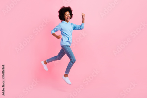 Full length profile portrait of delighted astonished person jumping raise fists isolated on pink color background