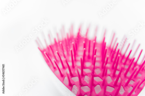 macro shot of the teeth of a white comb for hair extensions hair on isolated background