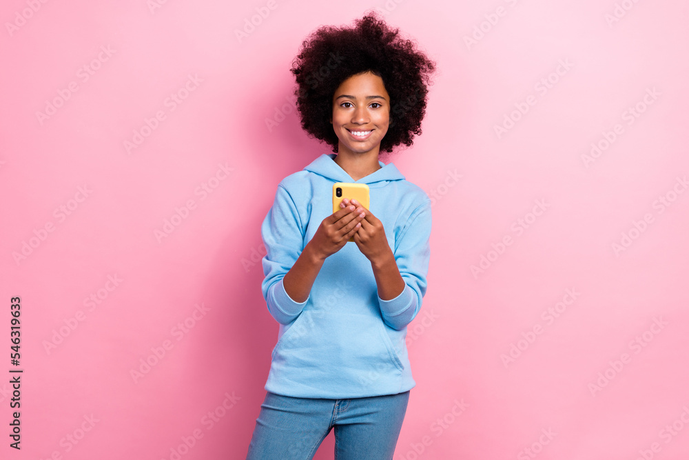 Photo portrait of cute little girl holding telephone toothy smile fast wifi dressed stylish blue clothes isolated on pink color background Photo portrait of cute little girl holding telephone toothy smile fast wifi dressed stylish blue clothes isolated on pink color background