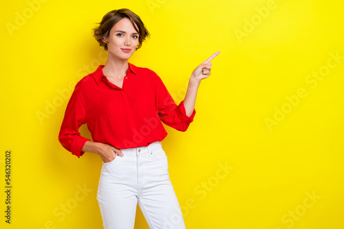 Photo of gorgeous nice sweet girl with bob hairstyle wear red shirt finger indicating empty space isolated on yellow color background