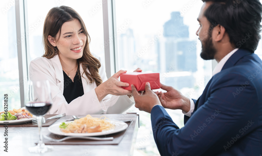 Unexpected moment in man's giving present to businesswoman with city background at restaurant hotel Unexpected moment in man's giving present to businesswoman with city background at restaurant hotel