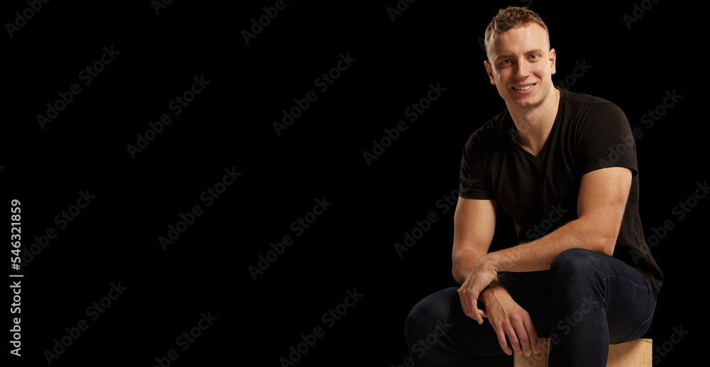 Fototapeta premium Portrait of young handsome man in casual clothes posing isolated over black studio background. Concept of fashion and lifestyle
