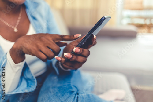 African American black woman working and using smartphone home. Portrait of african american woman using smartphone and smiling.