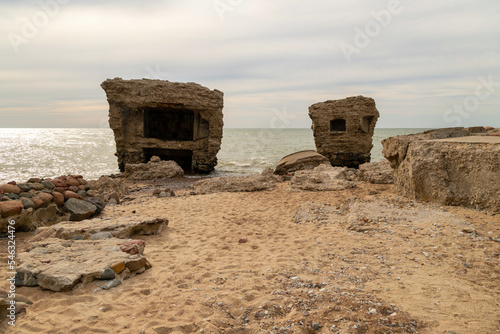 Abandoned buildings on the seashore in the water. War ruins decomposing in the Baltic sea. Former fort bunkers in Liepaja, Latvia.