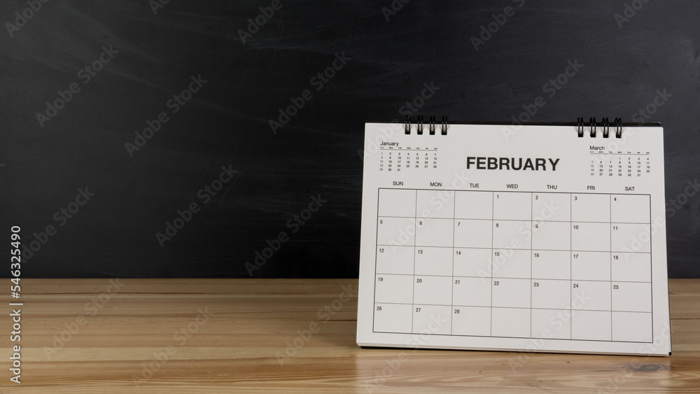 Fototapeta premium February calendar on wood desk white background. Feb 2023 agenda concept.