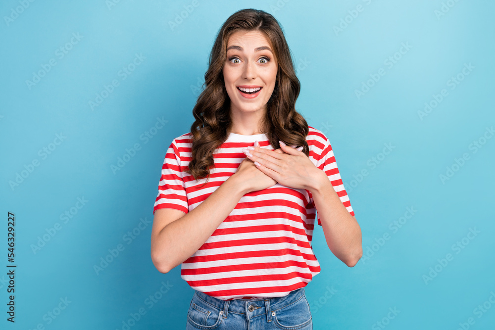 Photo of funny excited cheerful pretty woman curly hairstyle surprised touching heart good news reaction unexpected isolated on blue color background Photo of funny excited cheerful pretty woman curly hairstyle surprised touching heart good news reaction unexpected isolated on blue color background