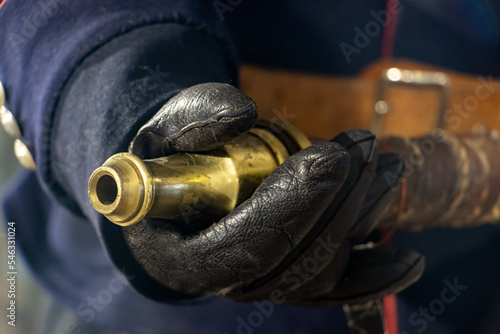 Close-up view of a hose with a nozzle in the hands of a firefighter in a retro uniform