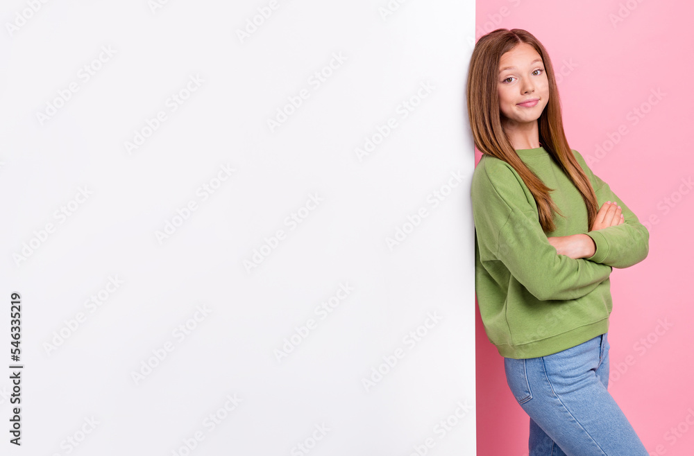 Photo of cheerful optimistic girl with straight hairstyle green sweater hands crossed lean on poster isolated on pink color background