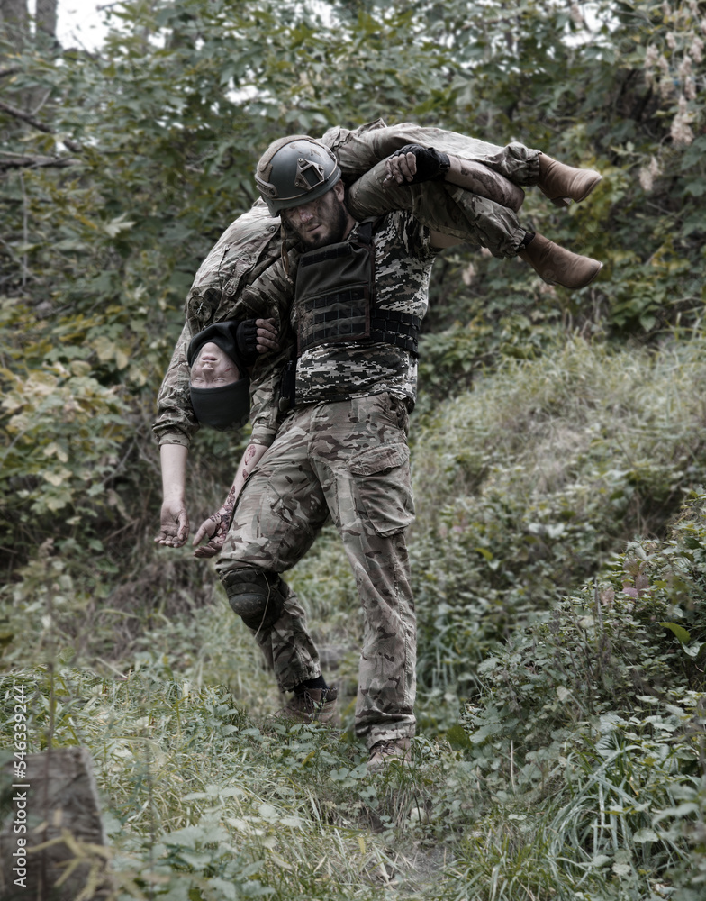 The commander carries a wounded soldier