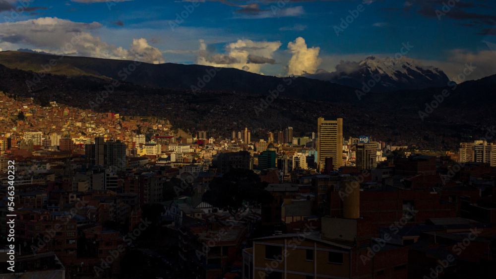 View of the city of La Paz illuminated by a ray of sun on a cloudy day.