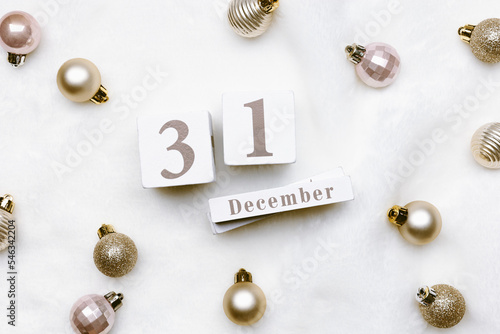Photography Happy New Year holiday background, calendar with date 31 december and christmas shiny balls on white fake fur