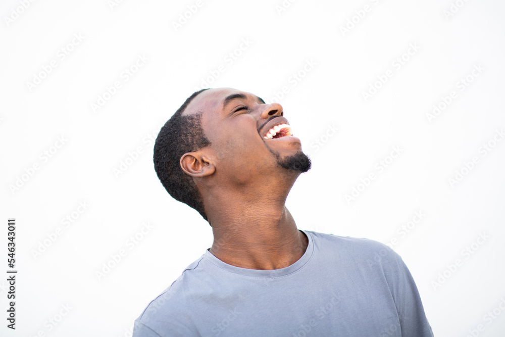 Fototapeta premium Cheerful young african american man laughing against white background