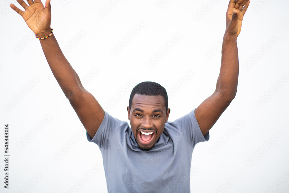 Excited young black man laughing with hands raised Excited young black man laughing with hands raised