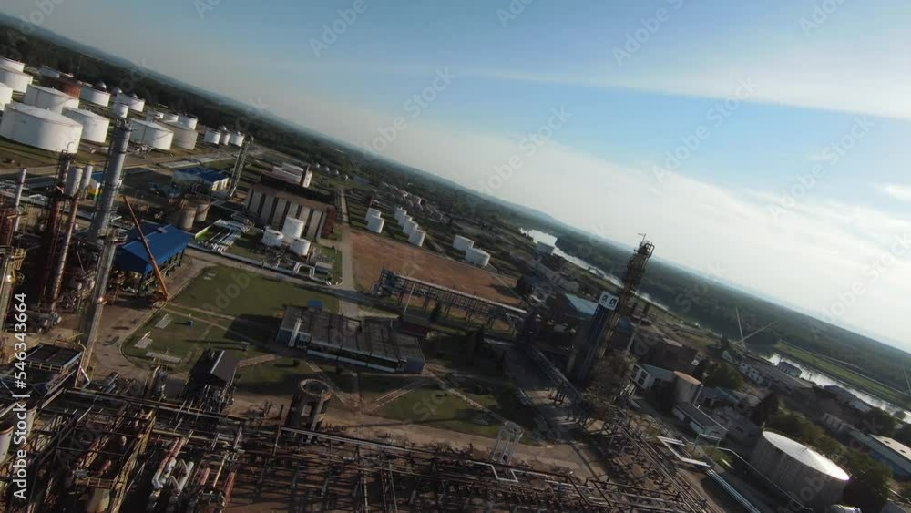 Aerial top down view over oil refinery or chemical factory and power plant with many storage tanks and pipelines. Shot with 4K UHD resolution drone.