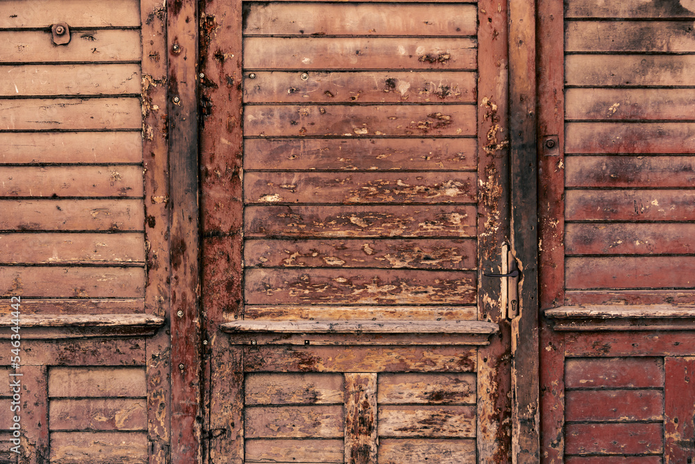 Old weathered and damaged maroon wood of a door or rustic entrance Old weathered and damaged maroon wood of a door or rustic entrance