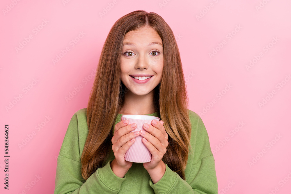 Photo of charming sweet school girl dressed green sweatshirt enjoying tasty beverage isolated pink color background Photo of charming sweet school girl dressed green sweatshirt enjoying tasty beverage isolated pink color background