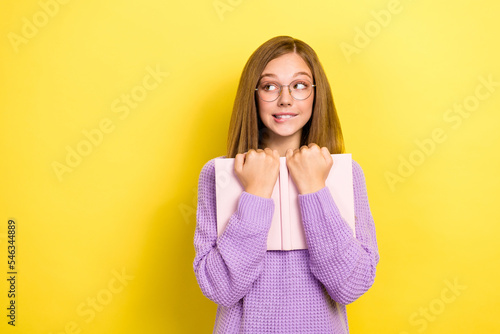 Photo of minded tricky lady schoolkid violet trendy jumper hold textbook interested look empty space isolated on yellow color background