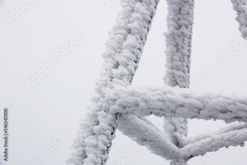 Iron tower covered with ice and snow in frosty winter day