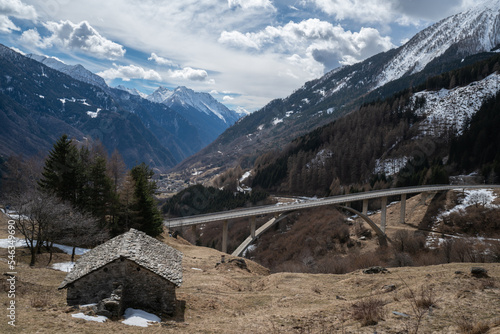 View from Pian San Giacomo on the descent from the San Bernardino pass to Mesocco in the Grisons, Switzerland, showing an old stone barn and a modern concrete bridge. photo