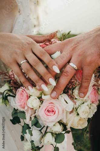 Fotobehang Vertical closeup shot of the bride and groom wearing their new wedding rings