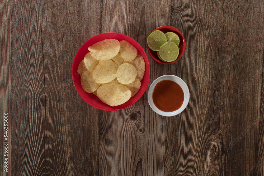 French fries snack with lemon and salsa for party on wooden table French fries snack with lemon and salsa for party on wooden table