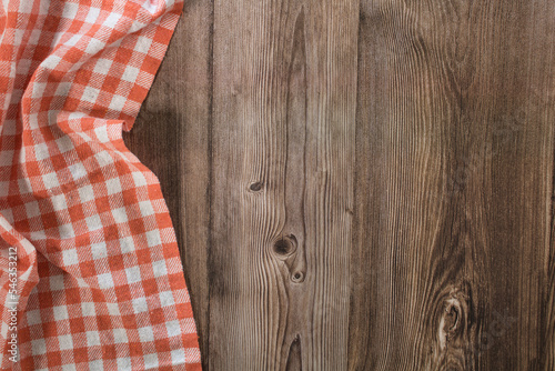 Background with wooden table with orange checkered tablecloth