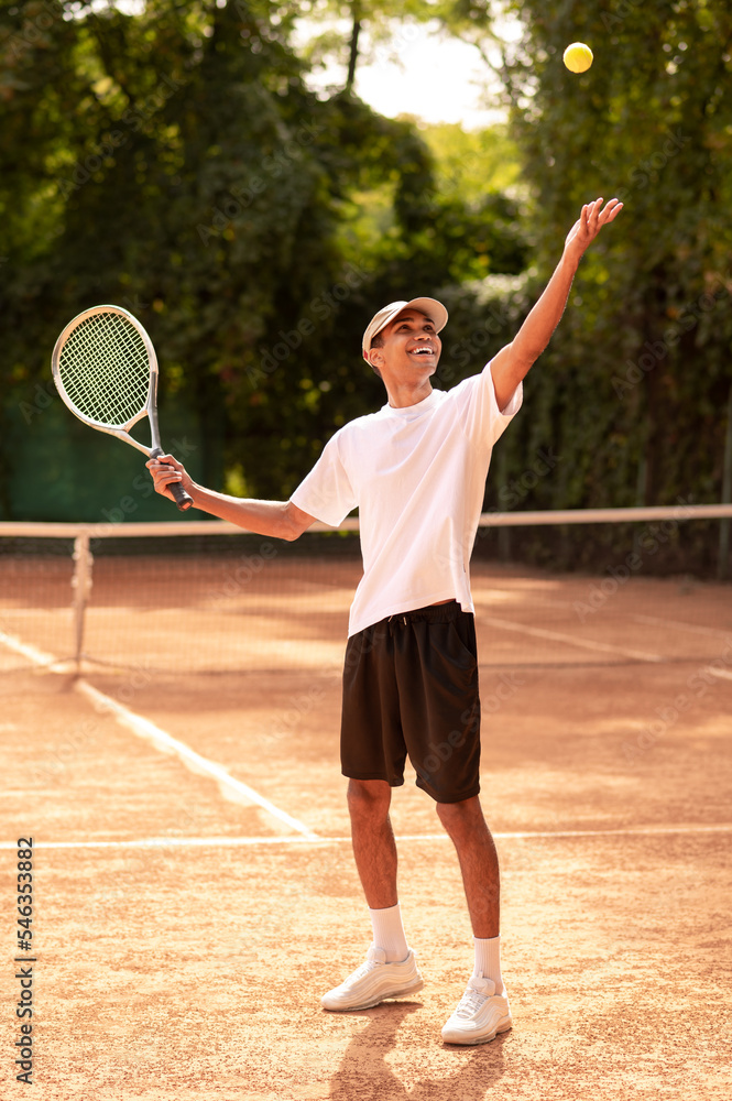 Young man in sportswear with a racket at the tennis court