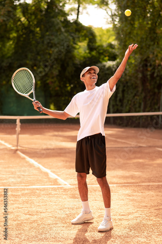 Young man in sportswear with a racket at the tennis court © zinkevych