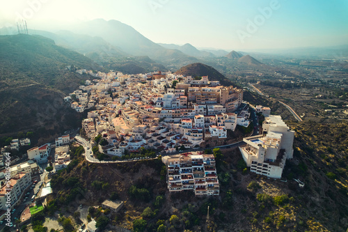 Aerial shot houses rooftops and mountains of Mojacar village. Spain photo