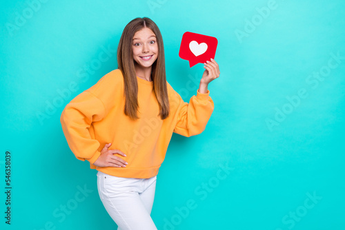 Photo of young excited popular teenager blogger hold red paper heart notification like her instagram account isolated on cyan color background