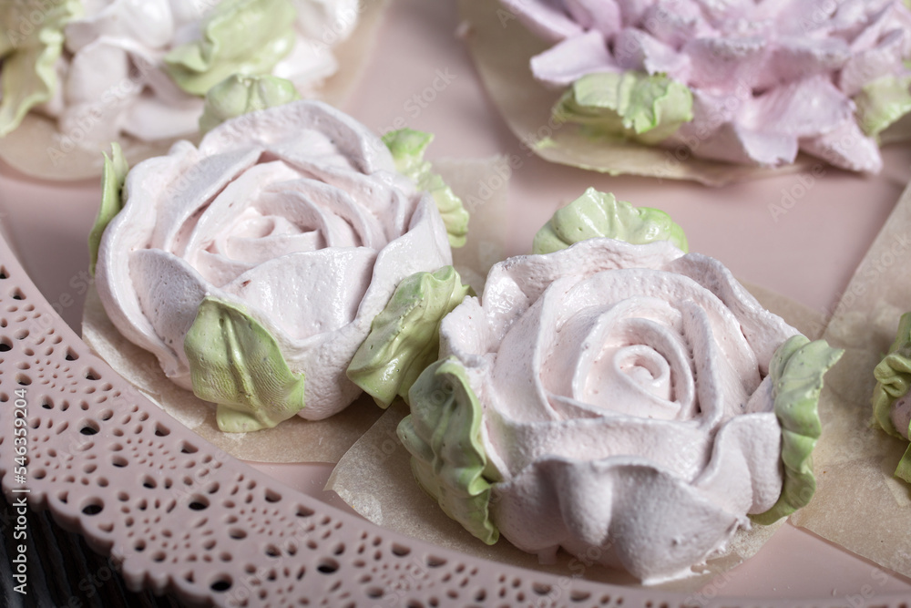 Marshmallow flowers on a tray. Zephyr flower buds. Homemade sweets. Against the background of pine boards. Shot close-up. Marshmallow flowers on a tray. Zephyr flower buds. Homemade sweets. Against the background of pine boards. Shot close-up.